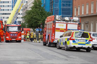 Stockholm, İsveç - 08 Haziran 2017: İsveç itfaiyeciler Stokholm, İsveç, kırmızı itfaiye araçları önünde 08 Haziran 2017 çalışan itfaiye için çalışma
