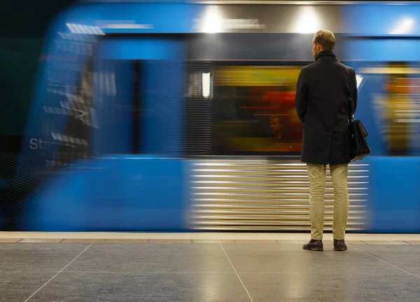 Achteraanzicht van de mens te wachten voor de metro, zijn gezicht reflecti — Stockfoto