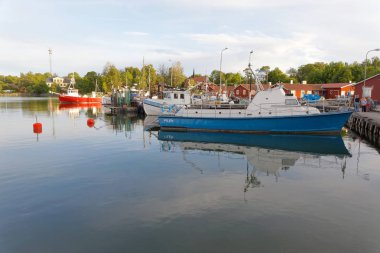 Grisslehamn, İsveç - 08 Temmuz 2017: tekneler küçük liman suda sabah erken yansıtan. Grisslehamn İsveç, 08 Temmuz 2017