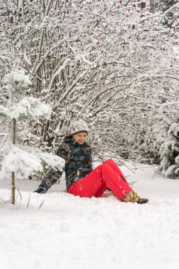 Karda oturan kız - kapalı bush kuşburnu altında