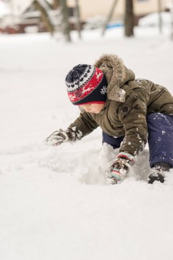 Çocuk kar ile oynuyor