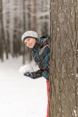 Güzel gülümseyen kız karda oynarken ve ambu için hazırlanıyor
