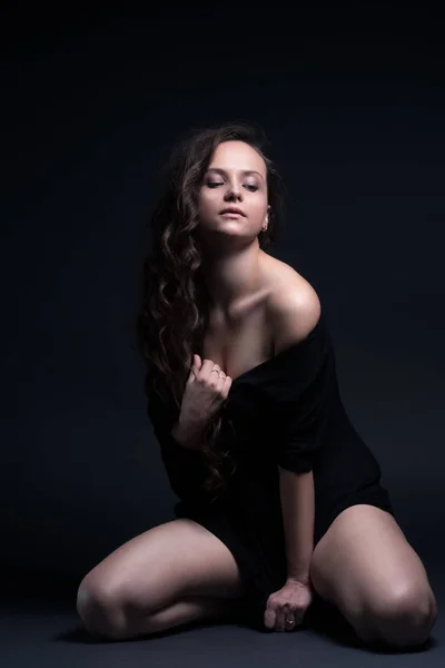 Genç güzel kız pozlar siyah bir zemin üzerine cinsel