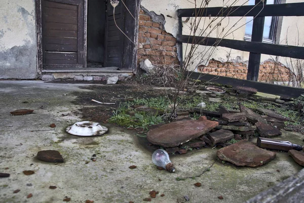 Old abandoned house and an ugly trash can.