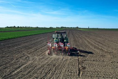 Curug, Sırbistan, 20 Nisan 2018. Bahar ekimi. Traktörlü bir çiftçi tarlasına mısır ekiyor..