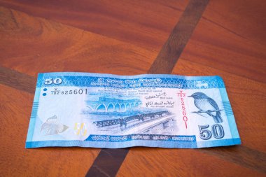 Masanın üzerinde elli rupi.