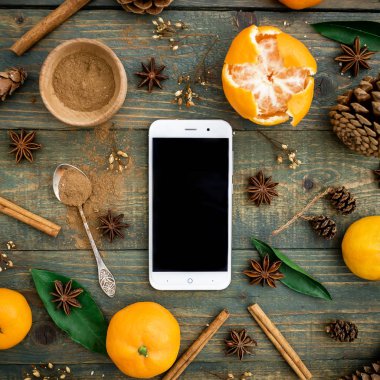 Smartphone, mandalina, koni ahşap arka plan üzerinde. Noel kavramı. Düz yatıyordu, en iyi görünümü kopya alanı