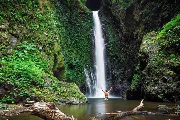 Man standing near beautiful waterfall — Stock Photo, Image