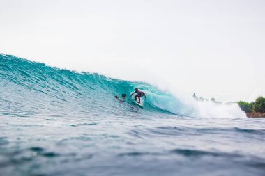 Gün batımında mükemmel okyanus dalgası üzerinde sürme sörfçü. Mayoyla sörf kış  
