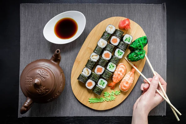 Mano tomando sushi delicioso — Foto de Stock
