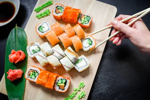 Rukou, přičemž lahodné sushi — Stock fotografie