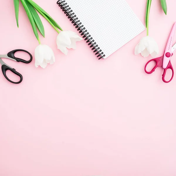 Flowers with notepad and scissors