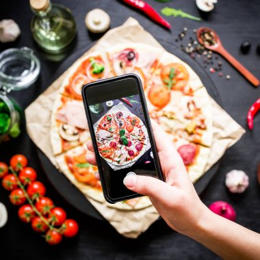 Taze pizza smartphone üzerinde çekim kadın