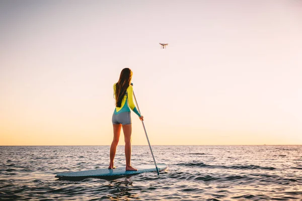 Chica de pie paddle boarding — Foto de Stock