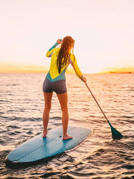 Chica de pie paddle boarding — Foto de Stock