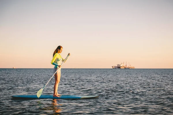 Chica de pie paddle boarding — Foto de Stock