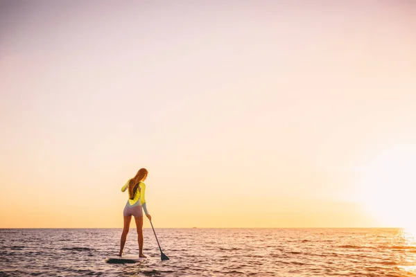 Chica de pie paddle boarding — Foto de Stock