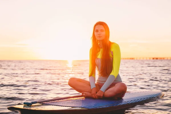 Ragazza seduta sul paddle board — Foto Stock