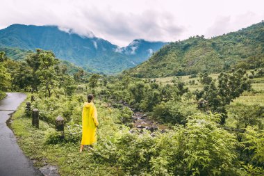 Kadın sarı montlu tropikal dağ manzarası doğal görünümünü arıyorsunuz