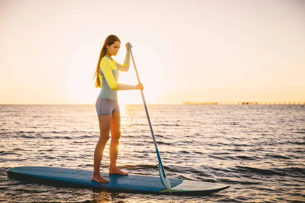 Menina levantar-se paddle embarque — Fotografia de Stock