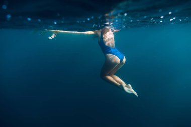 Sessiz bir okyanusta yüzen kadın.