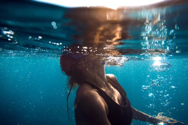 Sessiz bir okyanusta yüzen kadın.