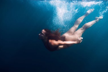 Sessiz bir okyanusta yüzen kadın.