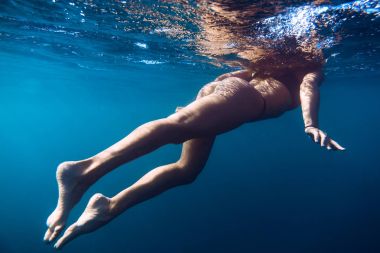 Sessiz bir okyanusta yüzen kadın.