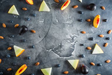 Şeftali, kavun, yaban mersini ve badem karanlık tablo çerçeve. Meyve kavramı. Düz yatıyordu, en iyi görünümü