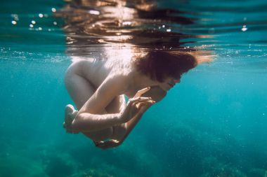 Sessiz bir okyanusta yüzen kadın.