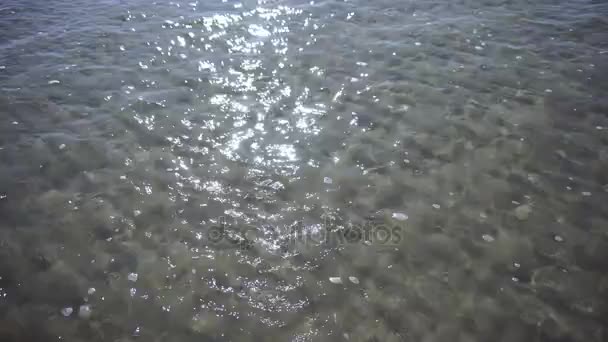 Océano con olas y arena en un día soleado. Textura natural — Vídeos de Stock