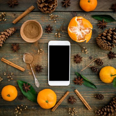 Smartphone, mandalina, koni ahşap arka plan üzerinde. Noel kavramı. Düz yatıyordu, en iyi görünümü kopya alanı