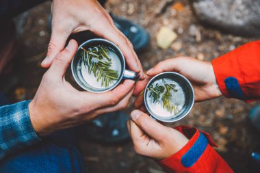 Adam ve içecekler çam çırpı ile iki bardak tutan kadın