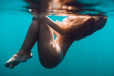 Sessiz bir okyanusta yüzen kadın.