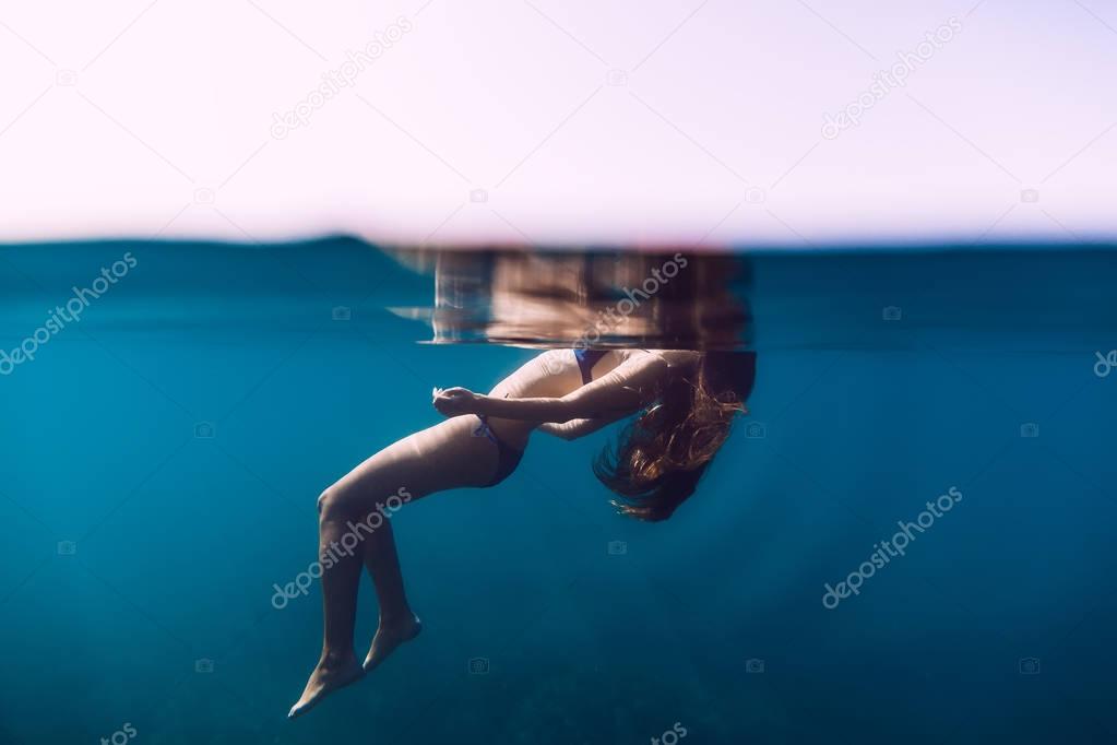 Woman  floating in quiet ocean.