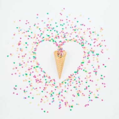 Beyaz arka plan üzerinde renkli şeker konfeti ve gözleme koni kalp sembolü yaptı. Düz yatıyordu