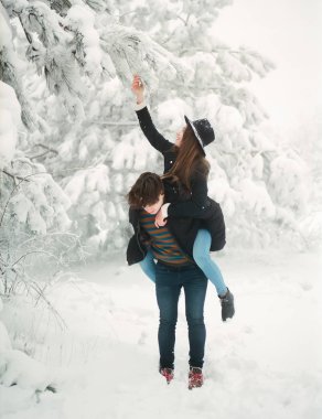 Genç çift eğleniyor. Kış aşk hikayesi ormandaki