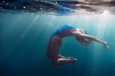 Sessiz bir okyanusta yüzen kadın.