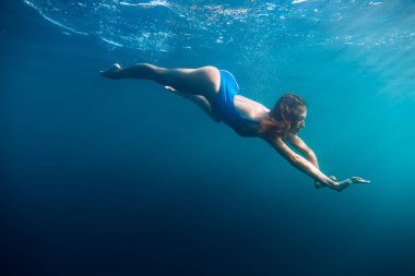 Sessiz bir okyanusta yüzen kadın.