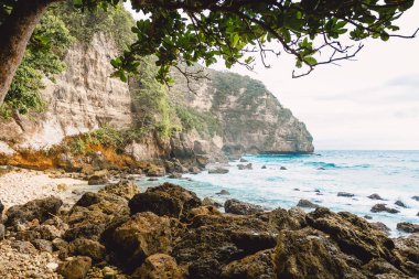 Tropikal mavi okyanus dalgaları ve Bali kayalık uçurum. Tropik cennet yerde