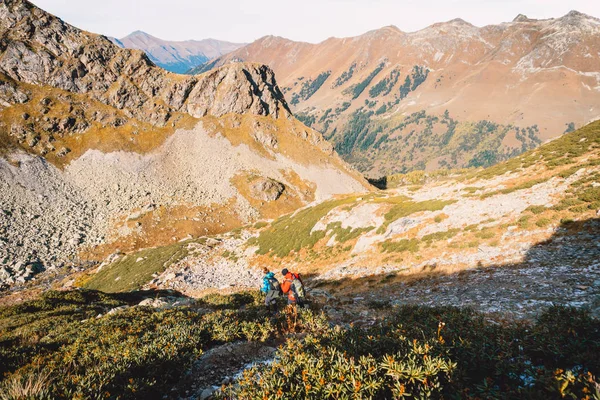 Hikers in the mountains. Tourists descend from the mountain