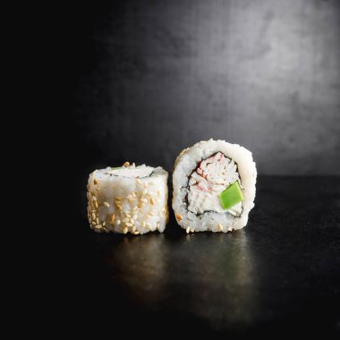 Lezzetli suşi siyah arka plan üzerine alır. Japon yemekleri