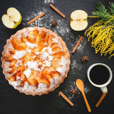 Charlotte pasta, kahve kupa, tarçın ve Mimoza çiçekler koyu arka plan üzerinde. Düz yatıyordu, en iyi görünümü.