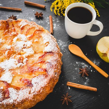 Charlotte pasta, kahve kupa, tarçın ve Mimoza çiçekler koyu arka plan üzerinde. Düz yatıyordu, en iyi görünümü.