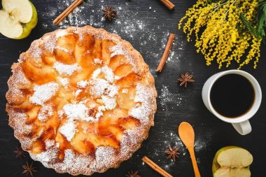 Charlotte pasta, kahve kupa, tarçın ve Mimoza çiçekler koyu arka plan üzerinde. Düz yatıyordu, en iyi görünümü.