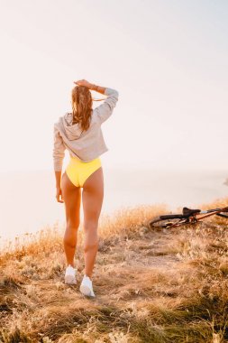 Mutlu kadın sıcak gün batımında doğada. Dağlarda mutlu tatil