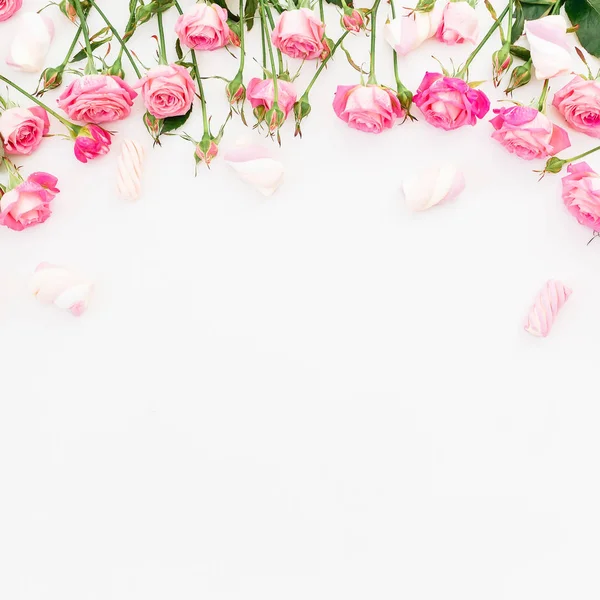 Pembe güller ve beyaz arka plan üzerinde hatmi çerçeve çiçek. Düz yatıyordu, en iyi görünümü.