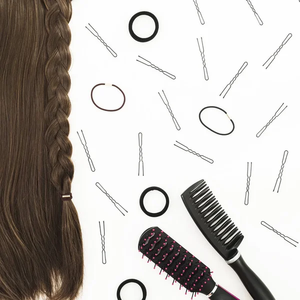 Frame with combs for hair styling, barrettes on white background. Beauty blog composition. Flat lay, top view