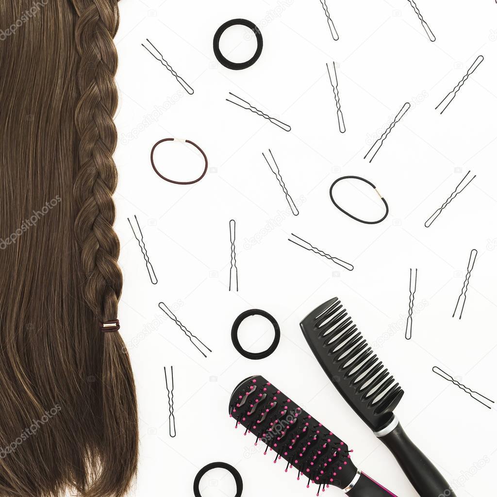 Frame with combs for hair styling, barrettes on white background. Beauty blog composition. Flat lay, top view
