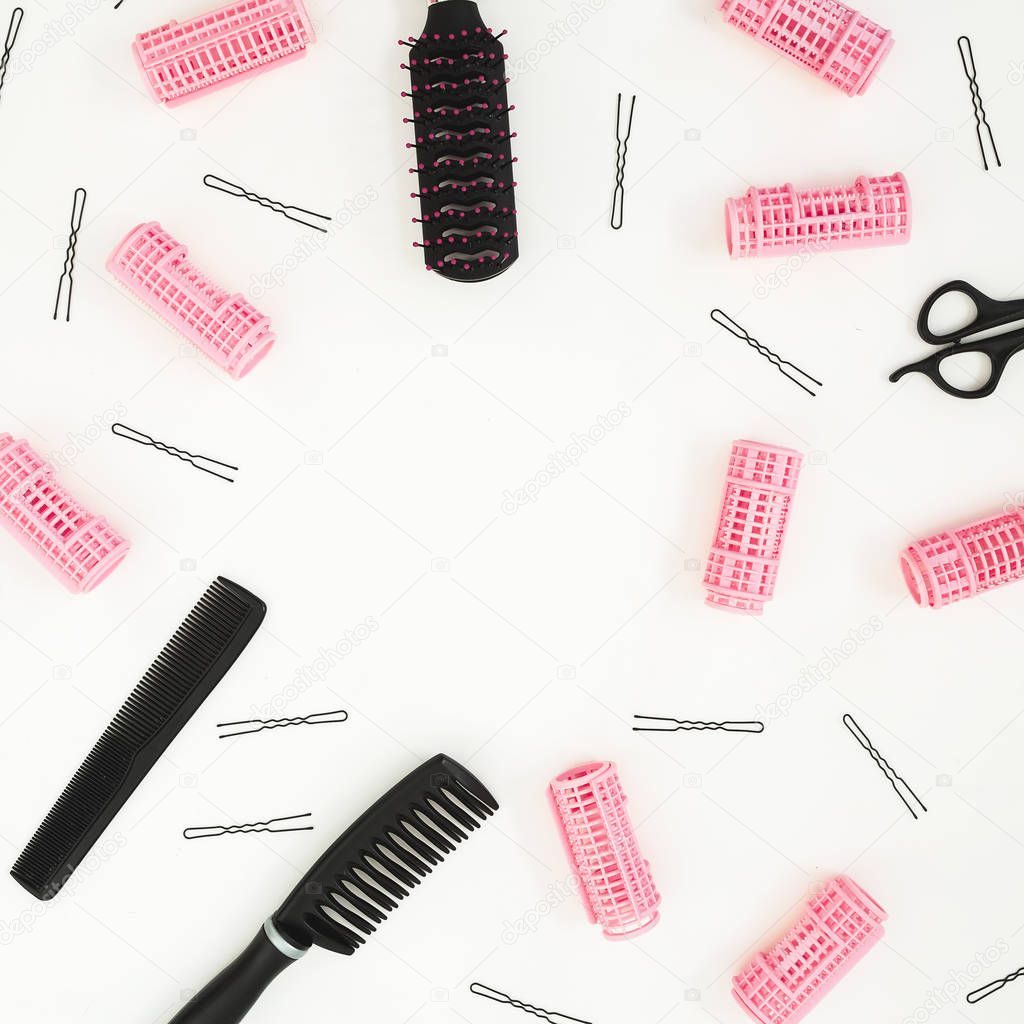 Frame with comb for hair styling, curlers and hairpins on white background. Beauty blog composition. Flat lay, top view